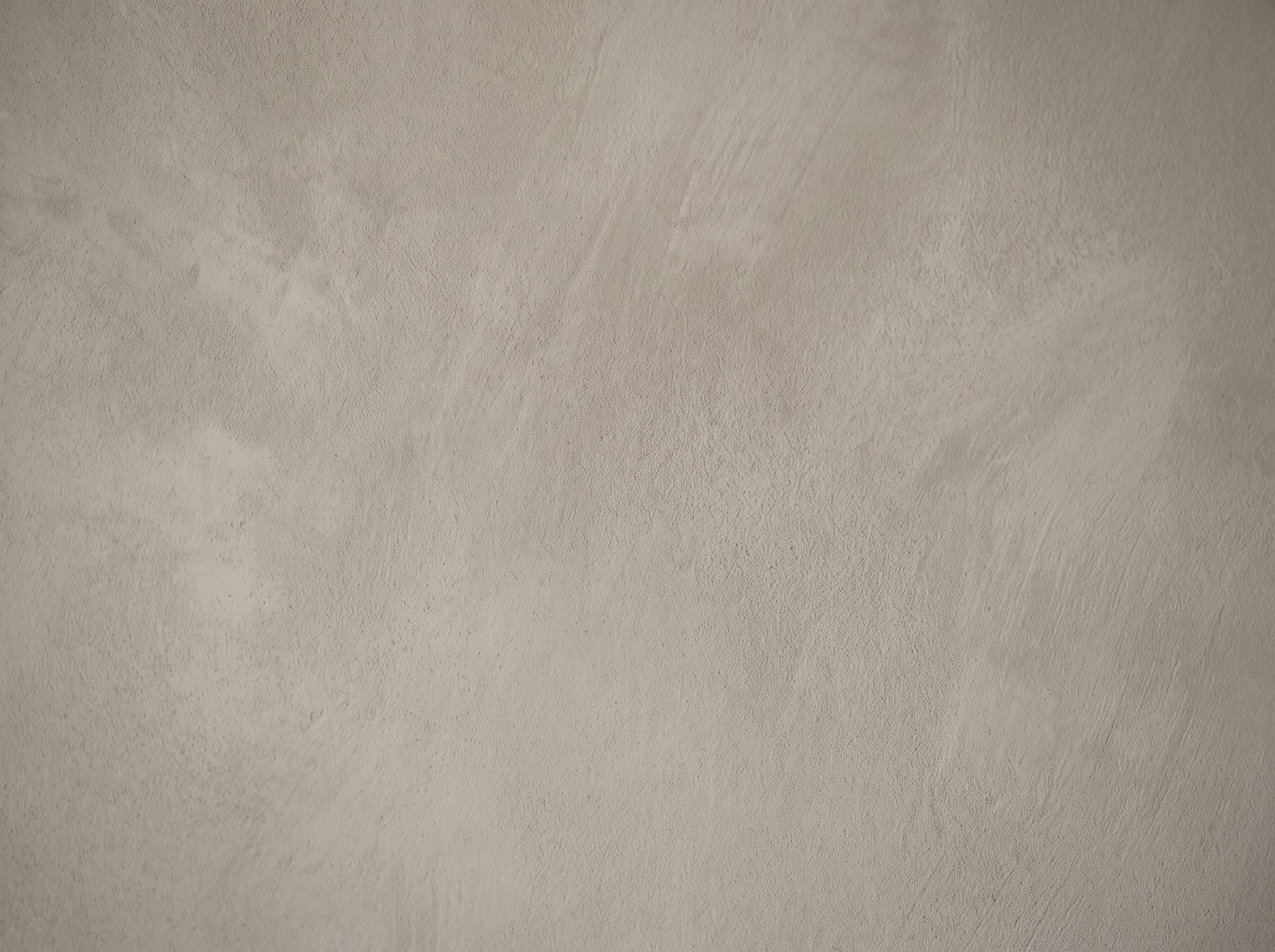 Close-up of brushed limewash showing pale and deep tones drifting across the wall